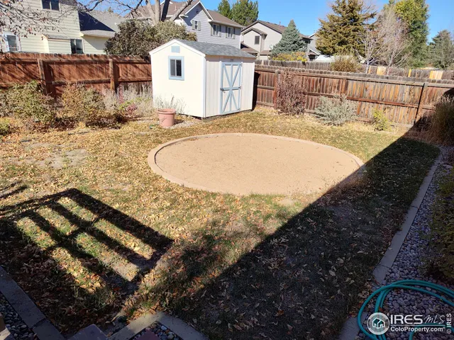 a view of a backyard with wooden fence