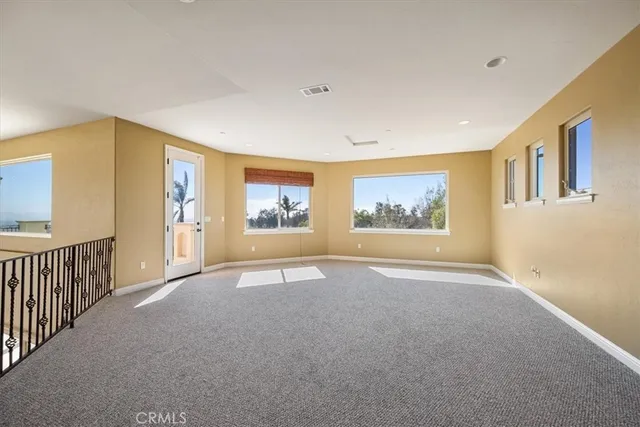 a view of a white house with a small yard and potted plants