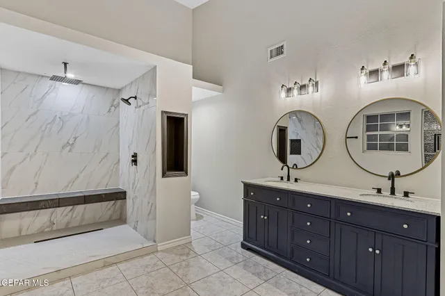 a bathroom with double vanity sink and a mirror