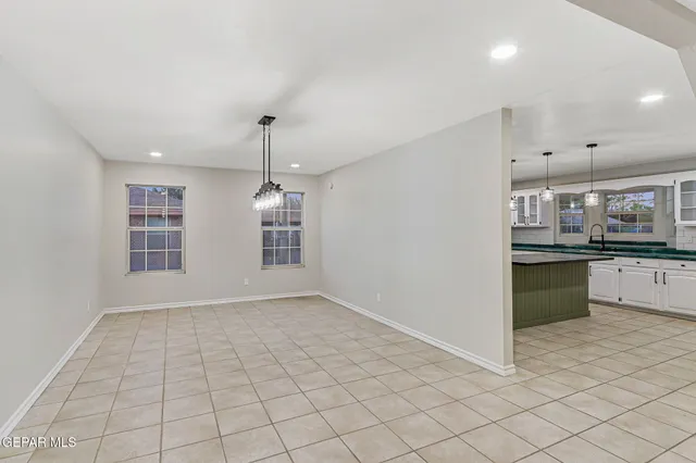 a view of empty room with a sink and chandelier