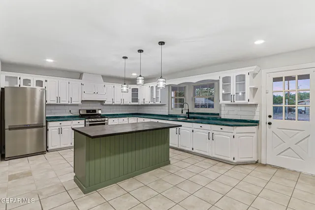 a kitchen with granite countertop white cabinets and a sink