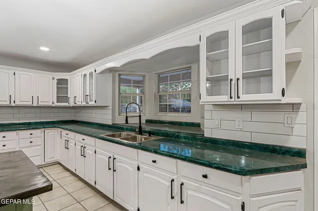 a kitchen with stainless steel appliances granite countertop a sink a stove a refrigerator and cabinets