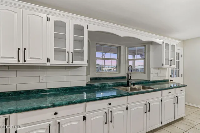 a kitchen with granite countertop white cabinets and white appliances