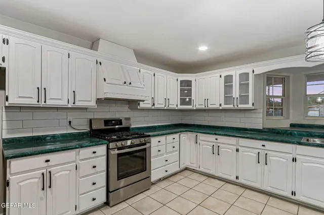 a kitchen with granite countertop white cabinets and white appliances