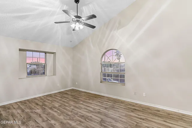 an empty room with fan and windows
