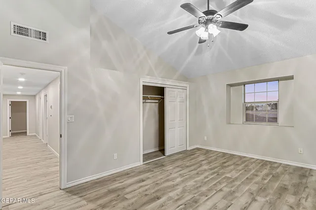 an empty room with a window and a fan