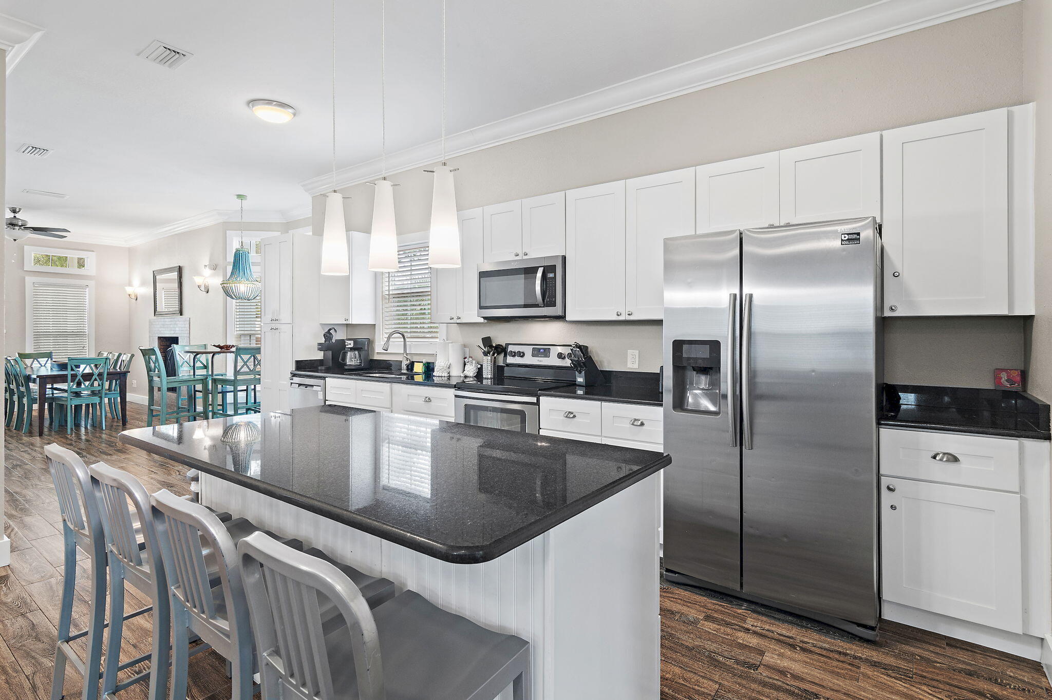 78 Pelican Glide Lane Inlet Beach, FL 32461 - Photo 10 of 61 a kitchen with stainless steel appliances granite countertop a refrigerator a stove a sink a dining table and chairs
