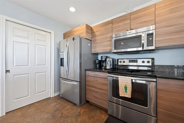 a kitchen with granite countertop stainless steel appliances and refrigerator