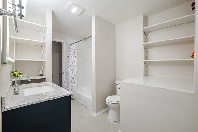 a bathroom with a granite countertop shower a sink and a mirror