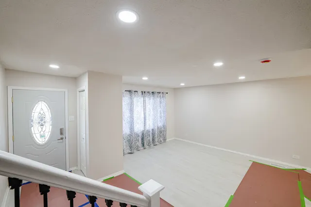 a kitchen with stainless steel appliances granite countertop white cabinets a sink a stove a microwave and wooden floors