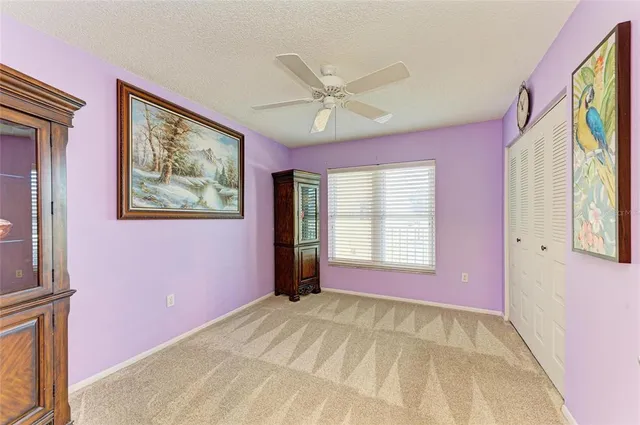 a view of an empty room with a window and a chandelier fan