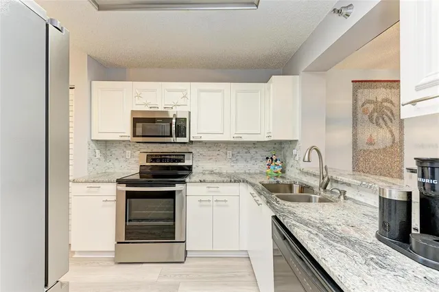 a kitchen with granite countertop a stove top oven and sink