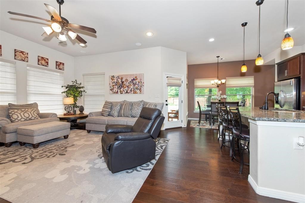8323 Floating Heart Court Conroe, TX 77385 - Photo 12 of 43 a living room with furniture a dining table and a chandelier