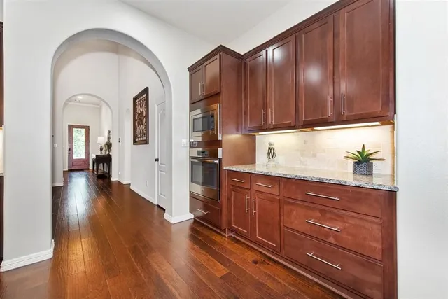 a view of a kitchen with wooden floor and cabinets