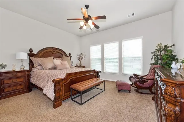 a spacious bedroom with a bed and a chandelier