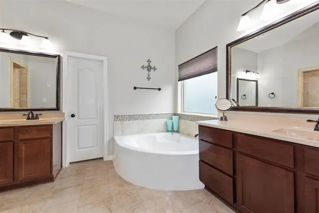 a bathroom with a tub a sink and mirror