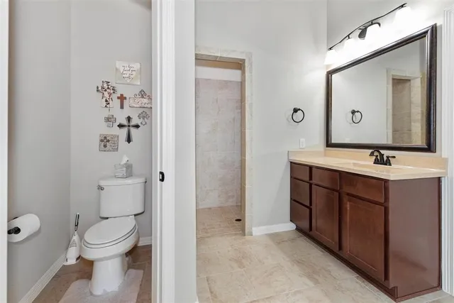 a bathroom with a toilet a sink a mirror a vanity and a window