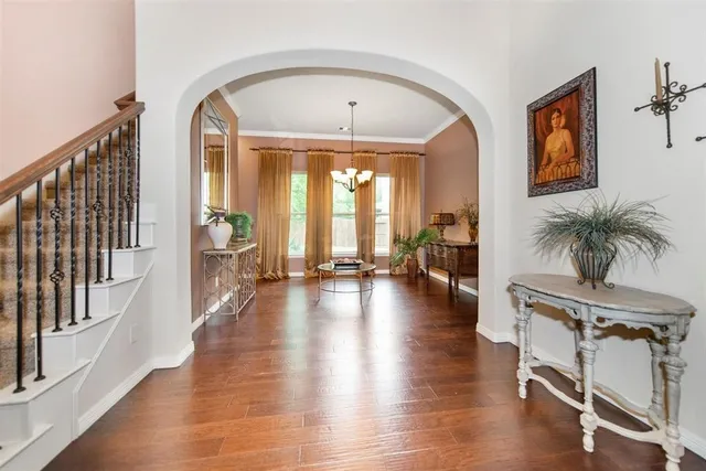 a view of a hallway with wooden floor and windows