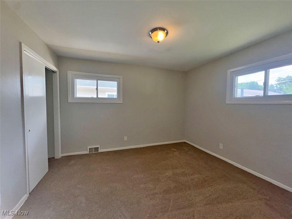 28642 Forest Road Willowick, OH 44095 - Photo 15 of 23 Unfurnished bedroom featuring a closet, multiple windows, and carpet