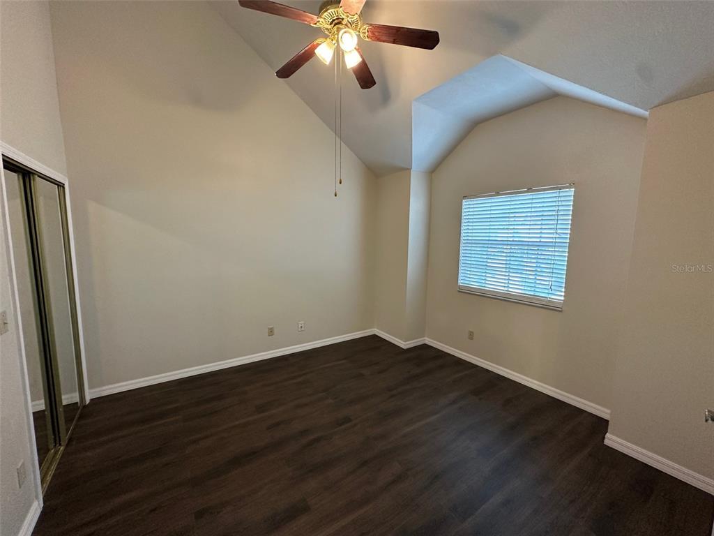 626 Cambridge Way, Unit 98 Altamonte Springs, FL 32714 - Photo 11 of 15 a view of an empty room with wooden floor and a ceiling fan