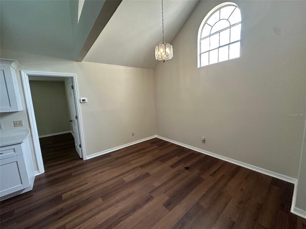 626 Cambridge Way, Unit 98 Altamonte Springs, FL 32714 - Photo 4 of 15 an empty room with wooden floor mirror and window