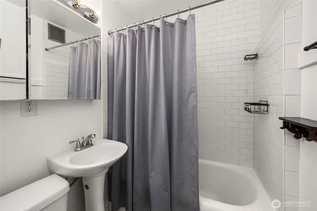 a bathroom with a sink a toilet and mirror
