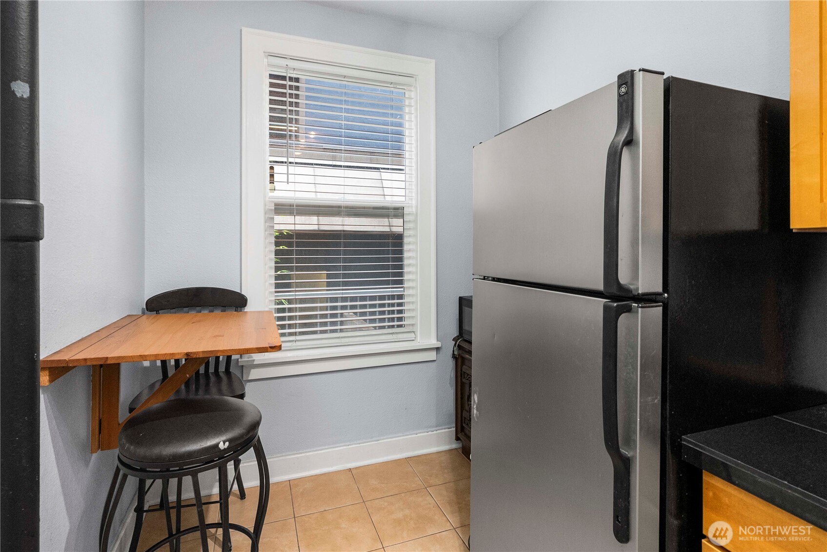 905 Northeast 43rd Street, Unit 107 Seattle, WA 98105 - Photo 9 of 30 a kitchen with a refrigerator and a table