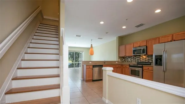 a kitchen with stainless steel appliances kitchen island granite countertop a refrigerator and a stove top oven