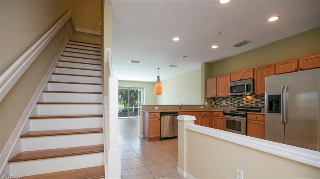 16097 Ravina Way, Unit 36 Naples, FL 34110 - Photo 4 of 19 a kitchen with stainless steel appliances kitchen island granite countertop a refrigerator and a stove top oven
