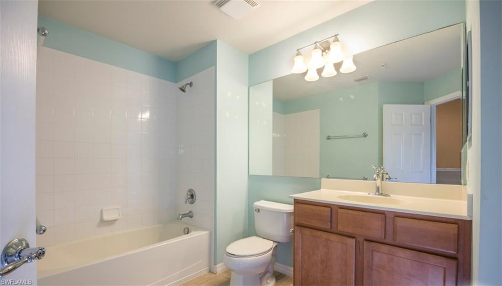 16097 Ravina Way, Unit 36 Naples, FL 34110 - Photo 7 of 19 a bathroom with a sink a toilet and a mirror