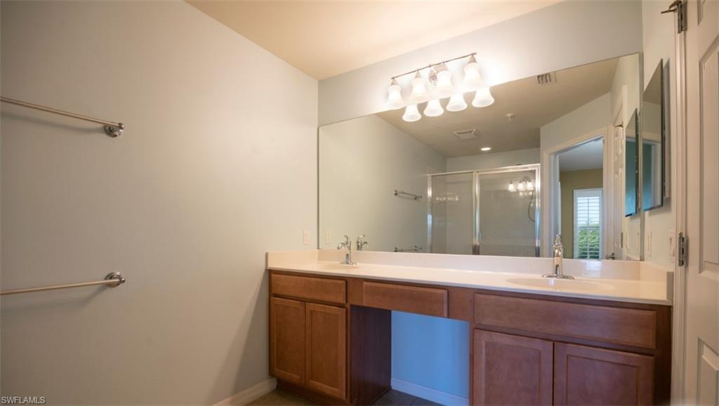 16097 Ravina Way, Unit 36 Naples, FL 34110 - Photo 9 of 19 a bathroom with a double vanity sink and a mirror