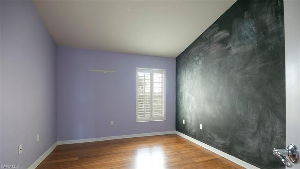 16097 Ravina Way, Unit 36 Naples, FL 34110 - Photo 10 of 19 a view of an empty room with wooden floor and a window