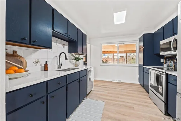 a kitchen with stainless steel appliances a stove sink and cabinets