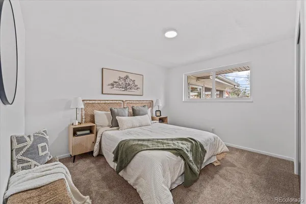 a bedroom with a bed and a painting on the wall