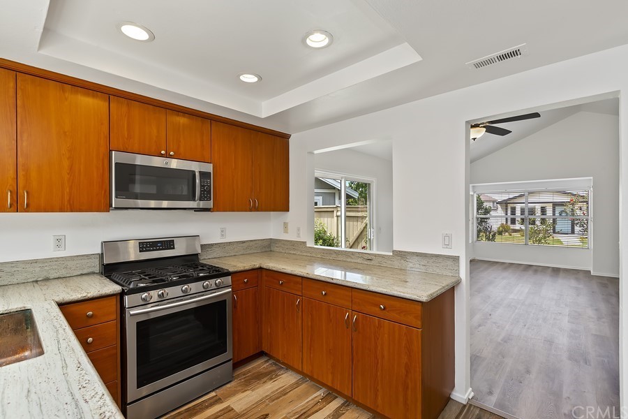 20 Wildwheat Irvine, CA 92614 - Photo 11 of 29 a kitchen with stainless steel appliances granite countertop a stove a sink and a microwave