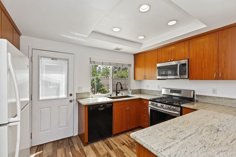 20 Wildwheat Irvine, CA 92614 - Photo 8 of 29 a kitchen with stainless steel appliances granite countertop a stove a sink and a microwave
