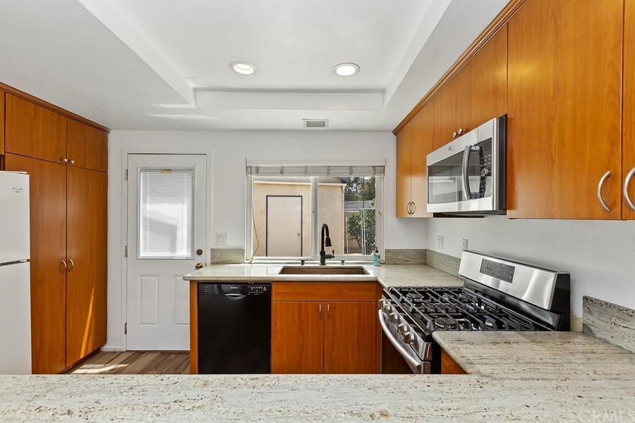 20 Wildwheat Irvine, CA 92614 - Photo 9 of 29 a kitchen with stainless steel appliances granite countertop a sink stove and refrigerator