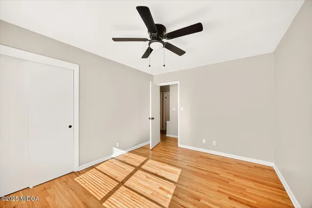 a view of empty room with wooden floor