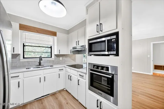 a kitchen with a sink stove and microwave