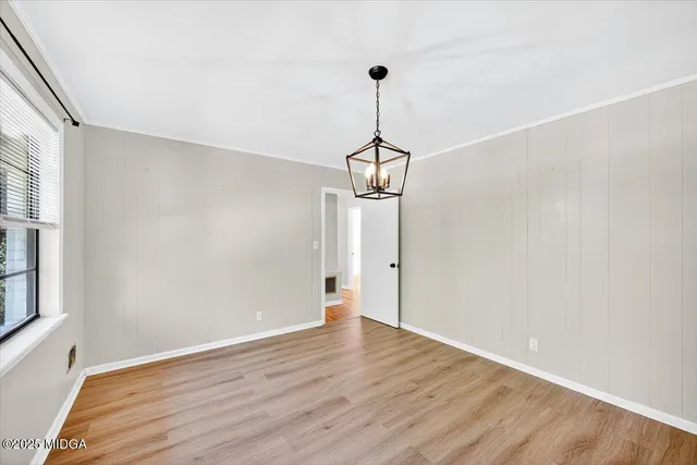 a view of empty room with wooden floor and windows