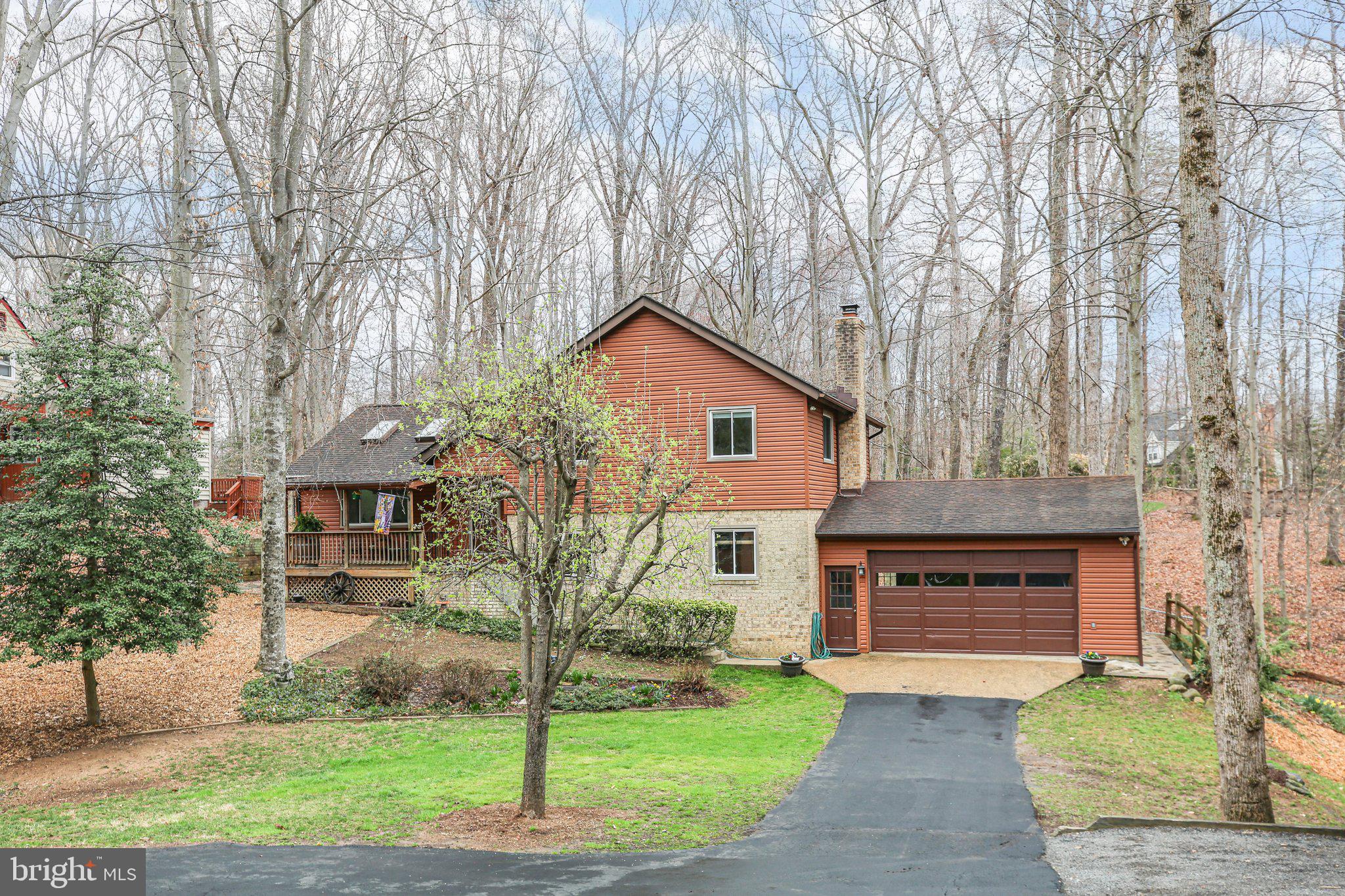 10831 Moore Drive Manassas, VA 20111 - Photo 2 of 52 a front view of a house with a garden and yard