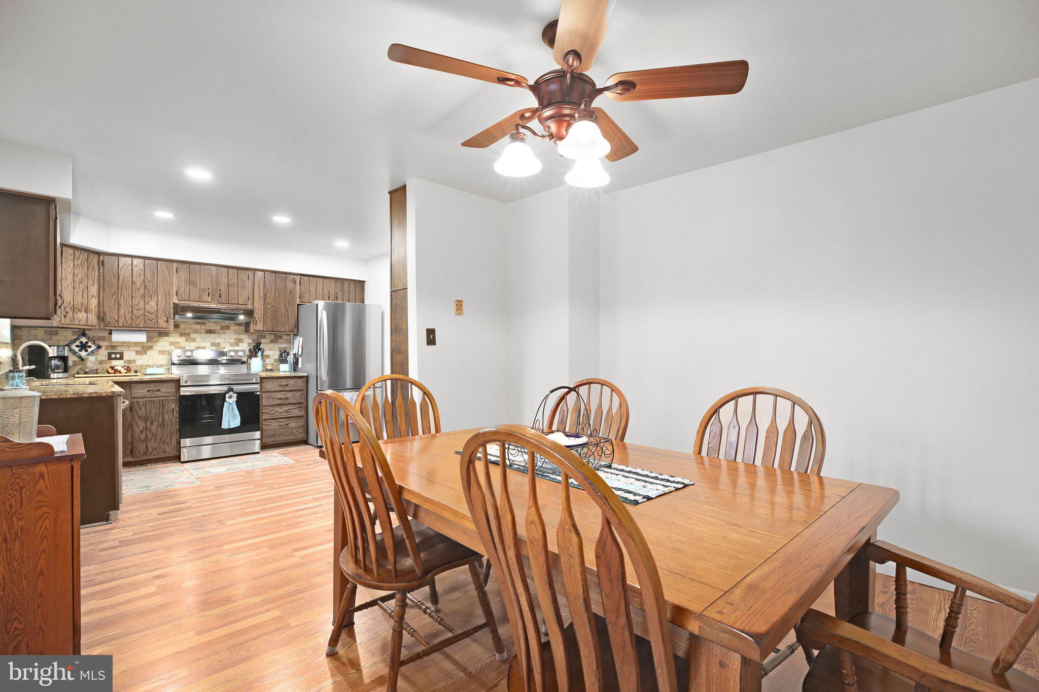 10831 Moore Drive Manassas, VA 20111 - Photo 6 of 52 a dining room with furniture a chandelier and wooden floor