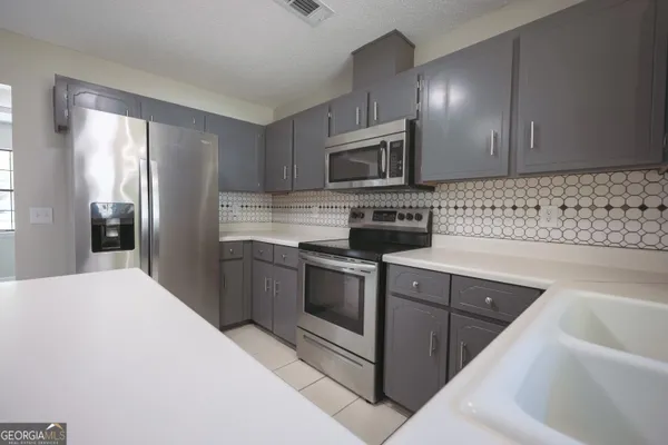 an empty room with wooden floor window and ceiling fan