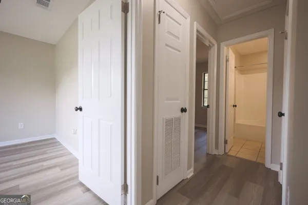 an empty room with closet and a chandelier fan