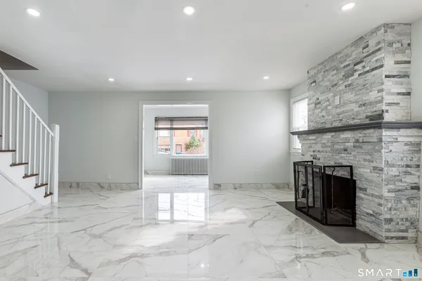an empty room with a fireplace and entryway
