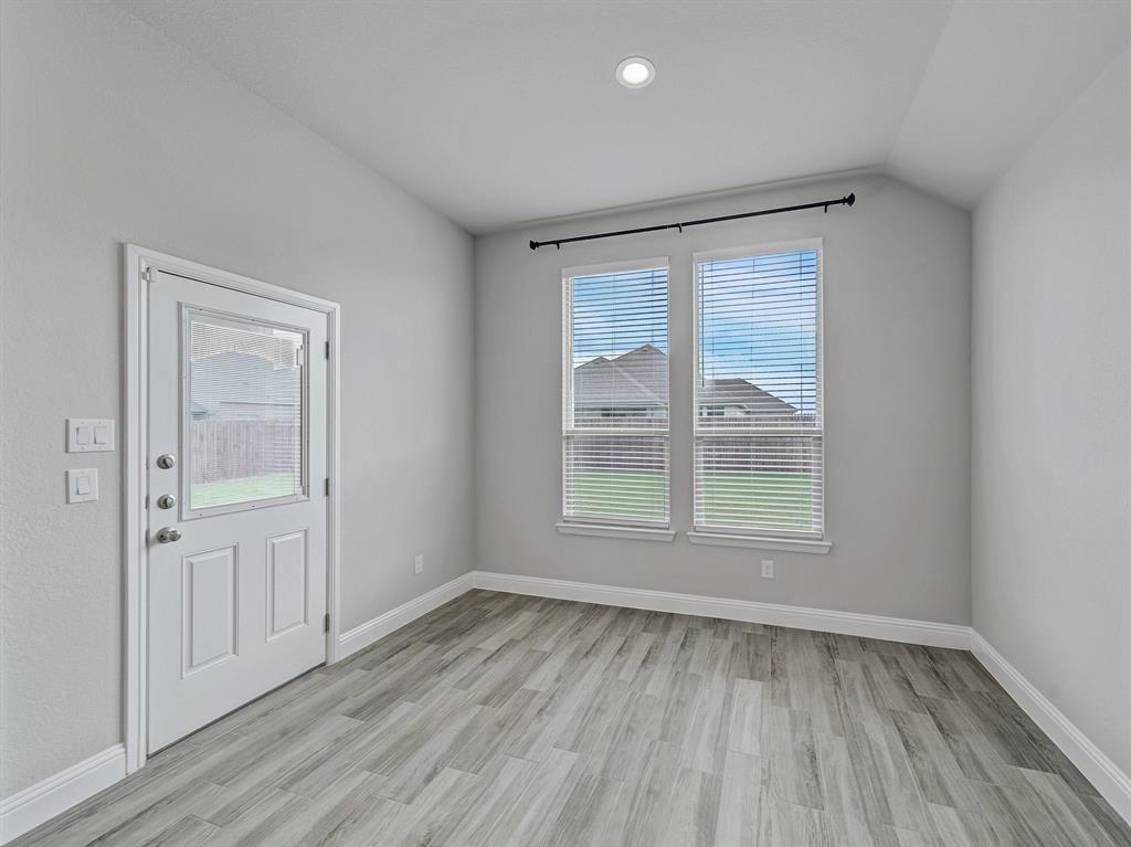3443 April Breeze Trail Grand Prairie, TX 76065 - Photo 11 of 29 an empty room with wooden floor and windows