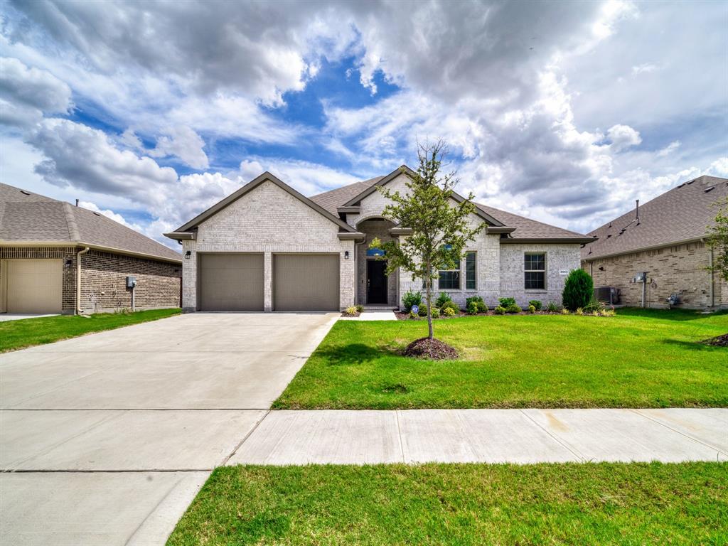 3443 April Breeze Trail Grand Prairie, TX 76065 - Photo 2 of 29 a front view of a house with a garden and yard