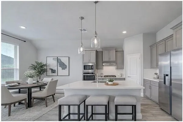 a kitchen with kitchen island stainless steel appliances a refrigerator and a stove top oven