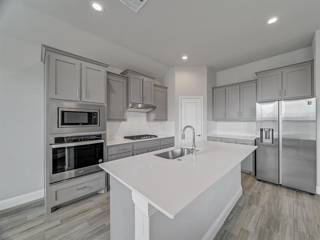 3443 April Breeze Trail Grand Prairie, TX 76065 - Photo 8 of 29 a kitchen with a sink a stove and refrigerator
