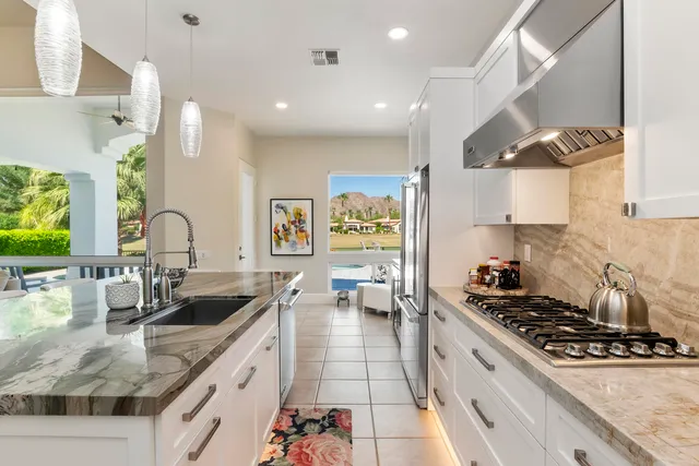 a kitchen with stainless steel appliances granite countertop a sink stove and cabinets